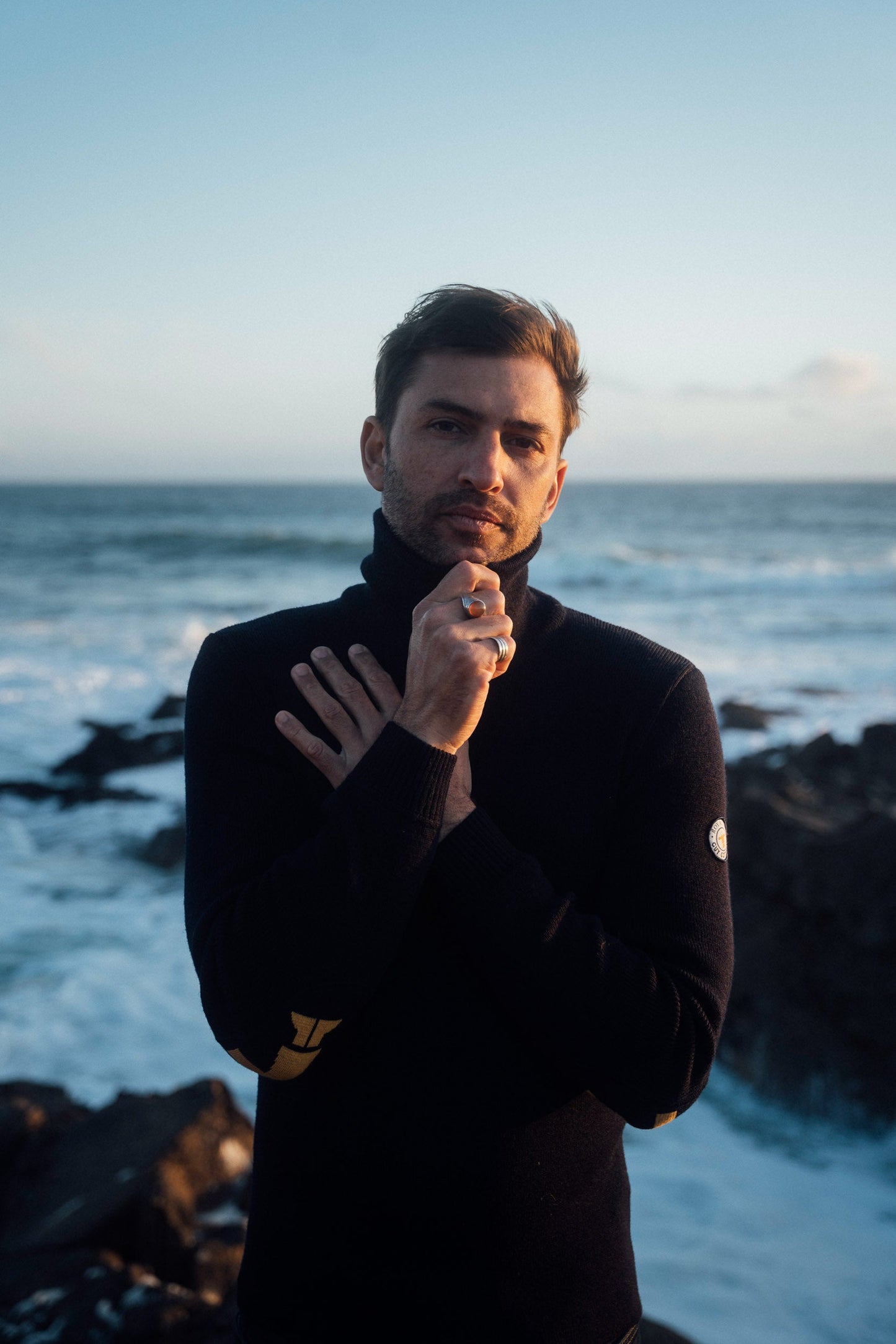 Homme portant le pull camionneur Royal Mer x Guy Cotten au bord de la mer